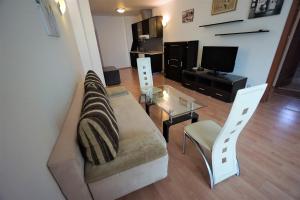 a living room with a couch and a glass table at Apartments in hotel Primorsko Del Sol in Primorsko