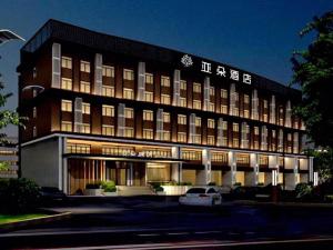 a hotel building with a car parked in front of it at Atour Hotel (Taiyuan Zonggai Shifanqu) in Taiyuan