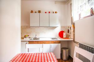 a small kitchen with white cabinets and a table at Apartman Japlenški in Delnice