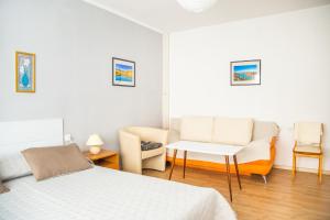 um quarto com uma cama, um sofá e uma cadeira em Apartman Japlenški em Delnice