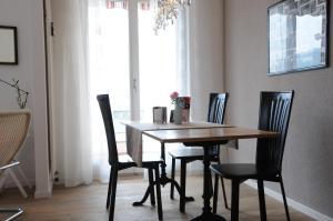 une table à manger avec quatre chaises et une fenêtre dans l'établissement Acquachiara, à Ponte Tresa