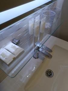 um lavatório com uma prateleira de vidro por cima de um lavatório em Travesia Rooms em Sarria