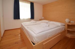 a bedroom with a large bed with a wooden headboard at Aurturist Dobbiaco Roulette in Dobbiaco +22 photos