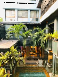 een binnentuin met palmbomen in een gebouw bij Blu Cabin Gay Poshtel in Bangkok