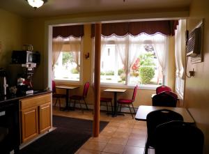 cocina con mesa, sillas y ventanas en Travelers Inn en Brunswick
