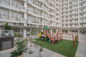 a large apartment building with a playground in the courtyard at RedDoorz Apartment @ Sentul Tower in Bogor