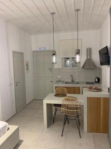a white kitchen with a table and chairs in it at Astra Studios in Astypalaia Town