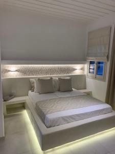 a white bedroom with a large white bed with lights at Astra Studios in Astypalaia Town