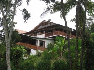 a house on a hill with palm trees at Spanish by the River - Turrialba in Turrialba