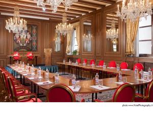 a conference room with long tables and red chairs at Grand Hotel Trento in Trento +81 photos