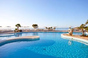 
a large swimming pool in a resort setting at Aparthotel Ponent Mar in Palmanova
