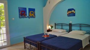 Duas camas num quarto com paredes azuis em Liogerma em Adamas