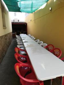 a row of tables and red chairs in a room at Casas Rurales TIO CLAUDIO I y II in El Barraco