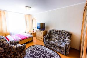 a living room with a couch chair and a television at Квартира на Козлова 13 in Salihorsk