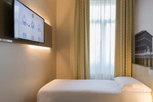 ローマにあるB&B Hotel Roma Pietralata Tiburtinaのベッド1台、薄型テレビが備わる客室です。