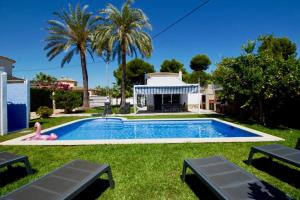 a swimming pool in the yard of a house with palm trees at Els Poblets WD by CARLOSFERIEN in Els Poblets
