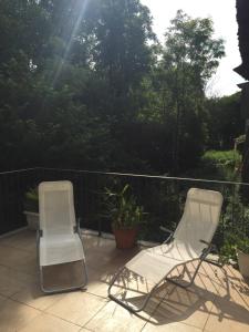 dwa krzesła siedzące na ganku ze słońcem w obiekcie Appartamenti a Magnano w mieście Magnano
