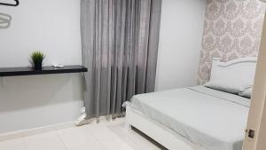 a white bedroom with a bed and a window at MELAKA HOMESTAY in Melaka