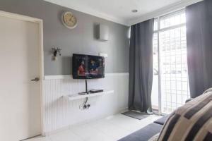 a living room with a television on a wall at MELAKA HOMESTAY in Melaka