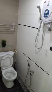 a bathroom with a toilet and a hair dryer on the wall at MELAKA HOMESTAY in Melaka