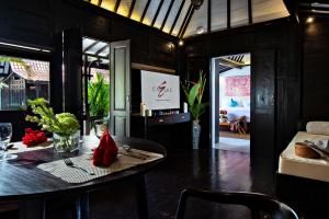 a dining room with a table and a living room at Canvas Escape Resort in Ubud