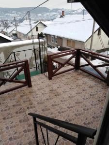 einen Balkon mit einer Bank und einem schneebedeckten Dach in der Unterkunft Apartman Vrdničak in Vrdnik