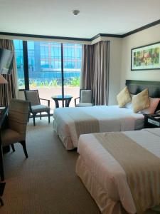 a hotel room with two beds and a balcony at Tower Inn Makati Business Hotel in Manila