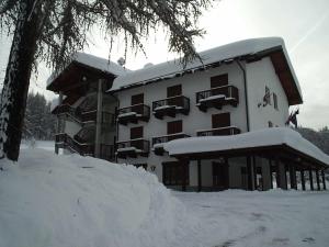 budynek pokryty śniegiem z stosem śniegu w obiekcie Park Hotel Gran Bosco w mieście Sauze dʼOulx