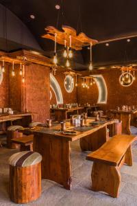 een restaurant met houten tafels en banken bij Chances Resort and Casino An Indy Resort in Panaji