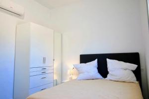 a bedroom with a bed with a white cabinet and pillows at Els Poblets WD by CARLOSFERIEN in Els Poblets +14 photos