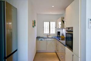 a kitchen with white cabinets and a sink at Els Poblets WD by CARLOSFERIEN in Els Poblets