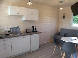 a kitchen and living room with a couch and a table at Domki na górce in Kołczewo