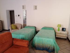 een woonkamer met 2 bedden en een bank bij Soggiorno in Centro Storico in Vimercate