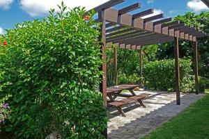 un banco de madera sentado bajo una pérgola de madera en Tsundara Beach Retreat, en Ishigaki Island