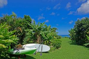 een surfplank en een boot op het gras bij Tsundara Beach Retreat in Ishigaki Island