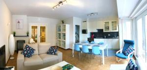 salon i kuchnia ze stołem i niebieskimi krzesłami w obiekcie Duinenblik 2 w mieście Nieuwpoort