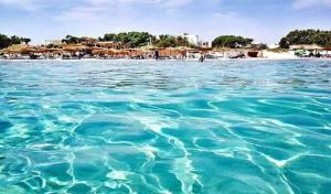 a large body of blue water with a beach at Maison pour vacance a Hammam Al Ghezaz in Kelibia