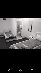 a white room with a bed and a bathroom at Apartmani Pinokio in Niš