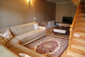Ayder İmamoğlu Apart Otel في آيدر يايلاسِه: غرفة معيشة بها أريكة وتلفزيون
