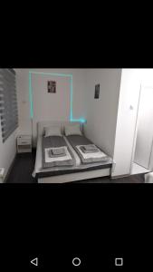 a room with a bed with a blue line on it at Apartmani Pinokio in Niš