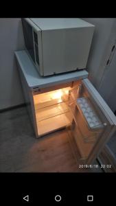 a small refrigerator with a microwave on top of it at Apartmani Pinokio in Niš