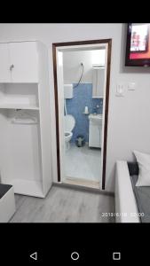 a bathroom with a door open to a bathroom with a toilet at Apartmani Pinokio in Niš
