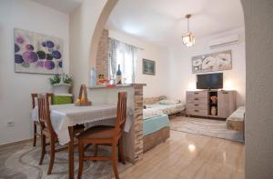 ein Wohnzimmer mit einem Tisch und ein Schlafzimmer in der Unterkunft Apartmani Dačo in Sveti Stefan