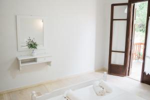 a white room with a mirror and a sink at Afroditi Pansion in Agios Nikitas