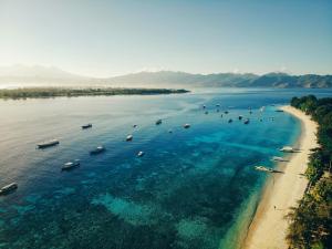 an aerial view of a beach with boats in the water at Vamana Resort - CHSE Certified in Gili Trawangan
