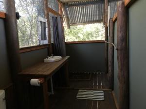 baño con lavabo y ventana en Phazama Farm en Maun
