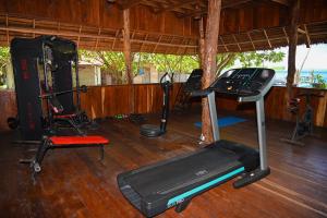 una habitación con un gimnasio con cinta de correr y otros equipos en Agusta Eco Resort, en Pulau Mansuar