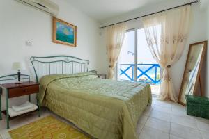 a bedroom with a bed and a window with a view at Villa Margo by the Sea in Paphos City