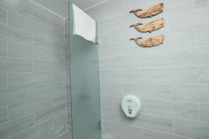 a bathroom with a shower with a white tiled wall at Cimer SafraMarine Beach Resort in Safra