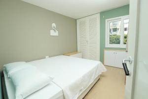 a bedroom with a white bed and a window at Cimer SafraMarine Beach Resort in Safra